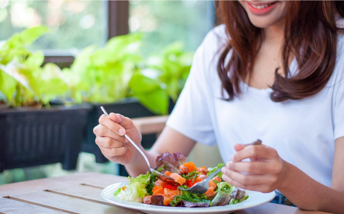 mujer comiendo ensalada
